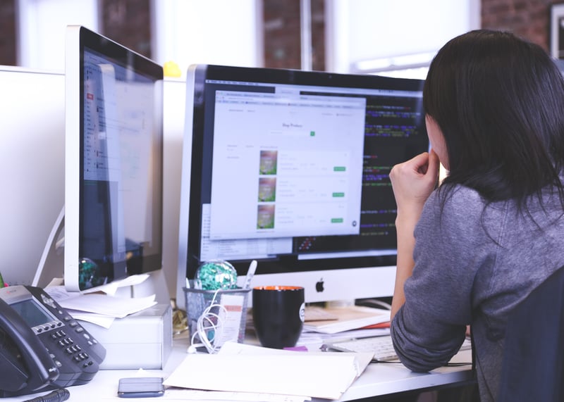 OnPath testing - a woman working at a desk with two monitors